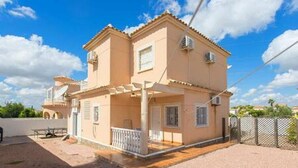 A two-story house with a balcony, a pergola, and a fenced yard. - CH Villa Cuenca Atalaya Park (Benijofar) (Ciudad Quesada)