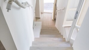 A staircase with white walls and wooden steps leading to an open door. - S186 - Sirolo, wonderful sky-earth in the historic center (Sirolo)