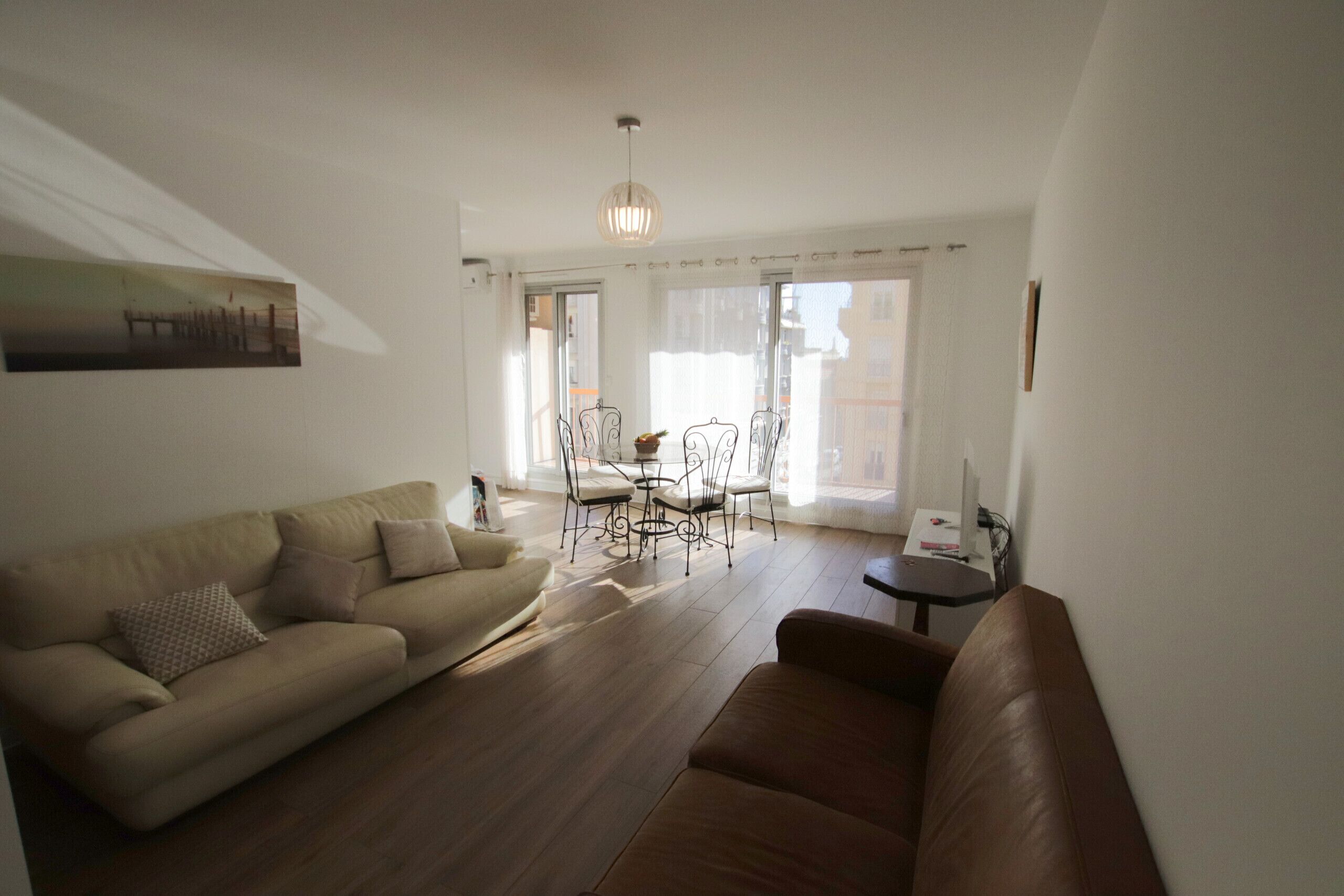 Una sala de estar con sofá, una mesa de centro y un comedor con sillas y mesa.