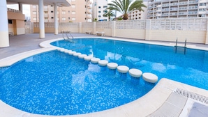 A swimming pool with steps leading into the water, surrounded by a tiled deck and a white fence. - BEGONIA - Apartment with sea views in Daimuz. Free WiFi (Daimús)