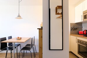 Une cuisine moderne avec un plan de travail en bois, un grille-pain rouge et un four encastré.