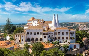 A historic building with multiple white facades, a prominent bell tower, and a courtyard with a fountain. - Apis Red Apartment, Cable TV, Wifi (Rinchoa)