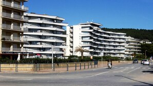 Un hotel de varios pisos con balcones y un restaurante en la planta baja.