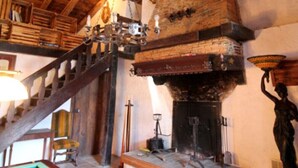 Ein rustikaler Raum mit einer Holztreppe, einem Billardtisch und einem Kamin.
