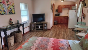 A compact living space with a television, kitchenette, and a patterned rug. - Gnome away from home (Sweetwater)