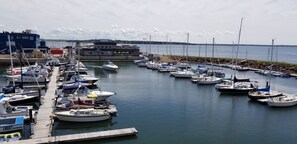 Un port de plaisance où sont amarrés différents types de bateaux, une jetée et un bâtiment arborant le drapeau canadien.