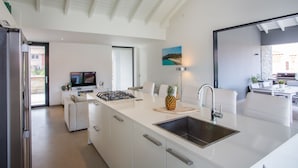 A modern kitchen with a large island, white cabinetry, and a stainless steel sink. - Hasta La Vista Royal – Tropical 7BR Villa for Groups, Jan Thiel (Jan Thiel)
