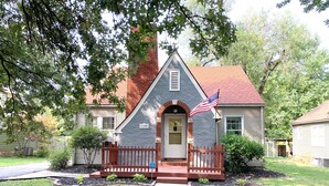 A house with a stone facade, a red roof, and a front porch.