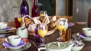 A breakfast table set with various dishes, including bread, pastries, and beverages.