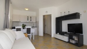 A modern living room with a sofa, TV, and entertainment unit. - Comfortable and charming apartment, beside the nature park (Premantura)