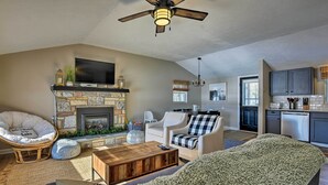 A spacious living room with a fireplace, comfortable seating, and a kitchen area visible through an open doorway. - Waterfront Pocono Lake Home w/ Private Dock! (Pocono Lake)