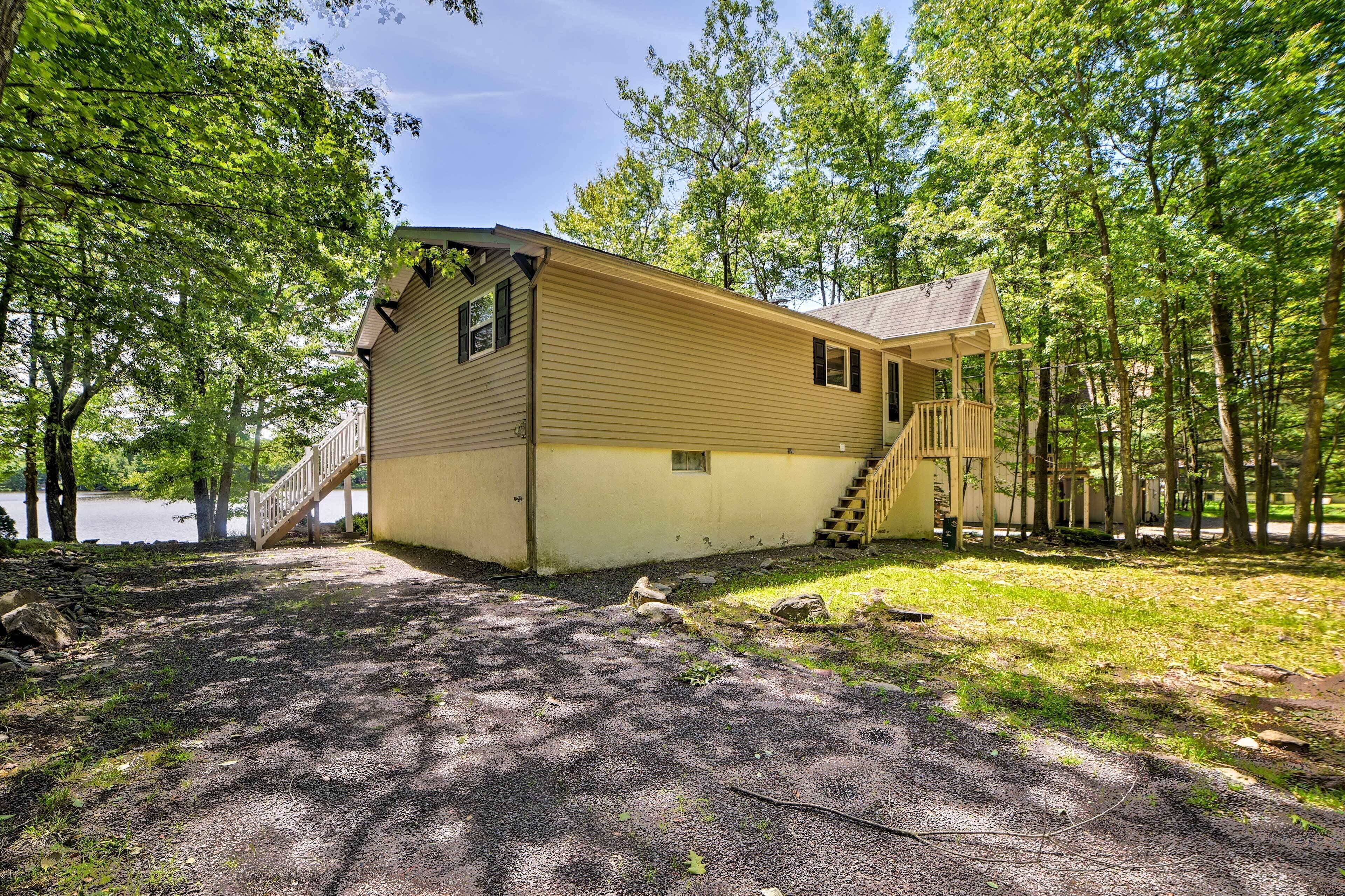 Une cabane dotée d’un porche et d’un escalier menant à l’entrée.