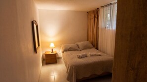 A small, cozy bedroom with a single bed, a bedside table with a lamp, and a mirror on the wall. - Alameda House   a beautiful apartment located in Medellín (Medellín)
