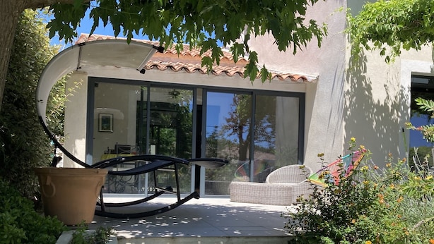 Un espace extérieur moderne avec un escalier en béton menant à un coin salon abrité.