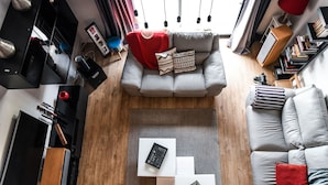 Un salon moderne avec un canapé gris, une table basse et une bibliothèque.