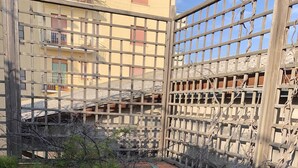A courtyard with a wooden fence, potted plants, and a building in the background. - Penthouse Anna, in the center of a small town with a splendid sea view (Ortona)