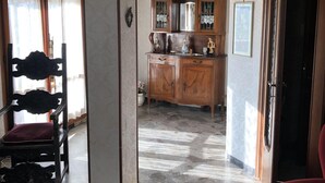 A room with a wooden cabinet, a red chair, and a marble floor. - Penthouse Anna, in the center of a small town with a splendid sea view (Ortona)