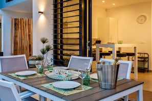 Enjoy a romantic dinner for two at this stylish dining area, complete with a long table set and elegant tableware.