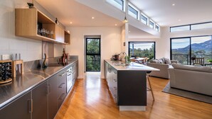 Una cucina moderna con isola centrale, mobili in legno e vista sull'esterno.
