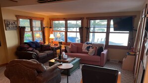 Ein gemütliches Wohnzimmer mit zwei Sofas, einem Couchtisch und einem Fernseher.