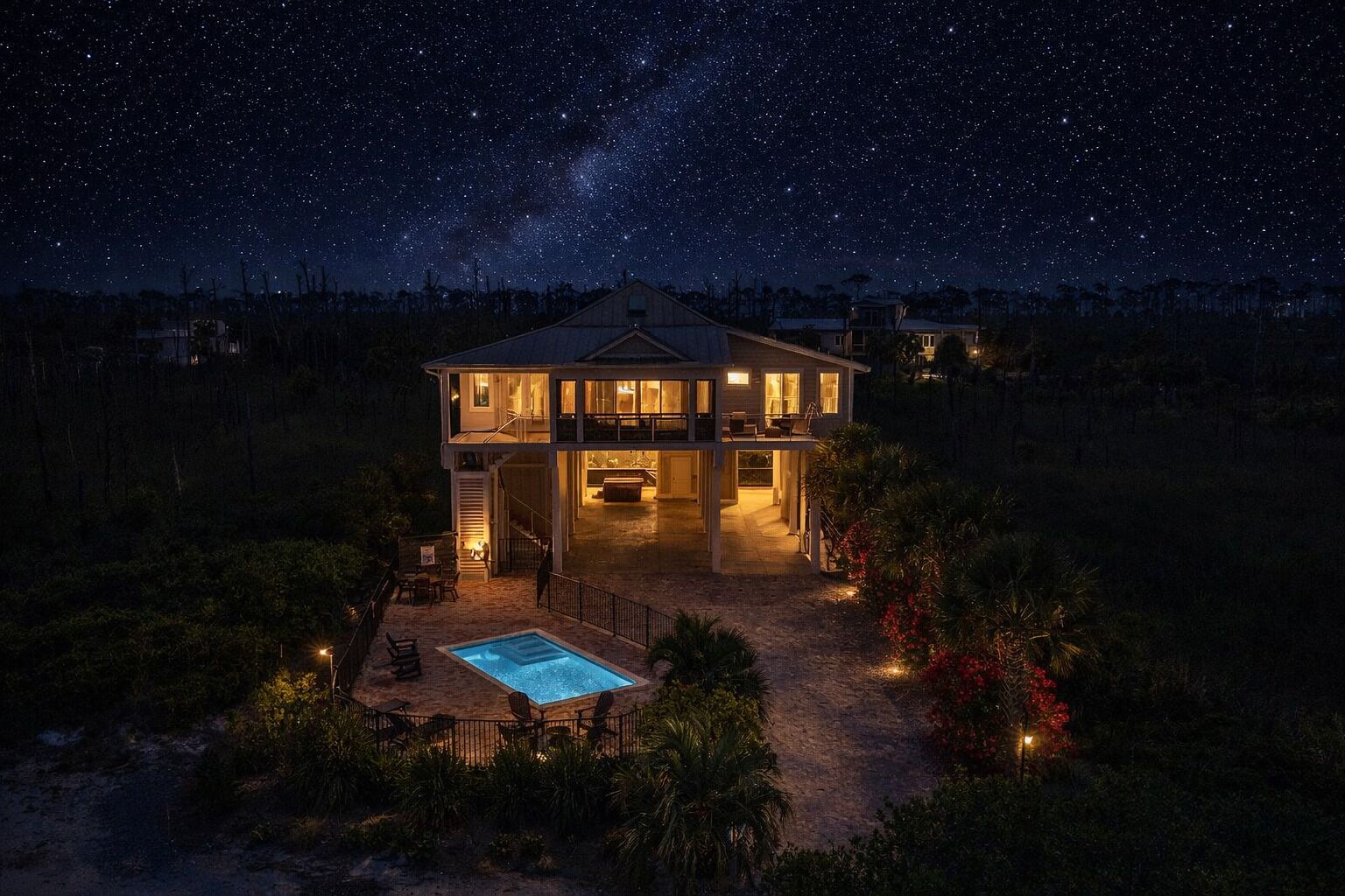 A two-story house with a pool, surrounded by vegetation, under a starry night sky.