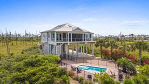 Ein zweistöckiges Haus mit Balkon, Swimmingpool und umgebendem Garten.