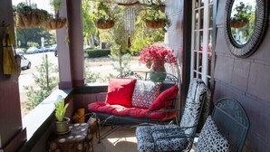 A balcony with wicker furniture, hanging plants, and a view of the street. - Fabulous Downtown Living, 1 BR/1 BA  (Santa Barbara)