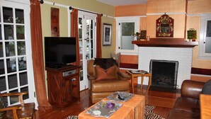 A living room with a television, leather armchair, fireplace, and a zebra-patterned rug. - Fabulous Downtown Living, 1 BR/1 BA  (Santa Barbara)
