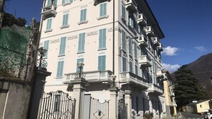 A multi-story building with balconies and a gated entrance. - Larius Apartment Carate Urio (Carate Urio)