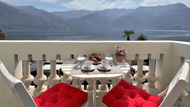 A terrace with a table set for two, overlooking a lake with mountains in the background. - Larius Apartment Carate Urio (Carate Urio)