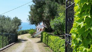 A pathway leading to a building with a view of the sea. - Villa Anna – Sea view attic with terrace, just minutes from the beach (Fuscaldo Marina)