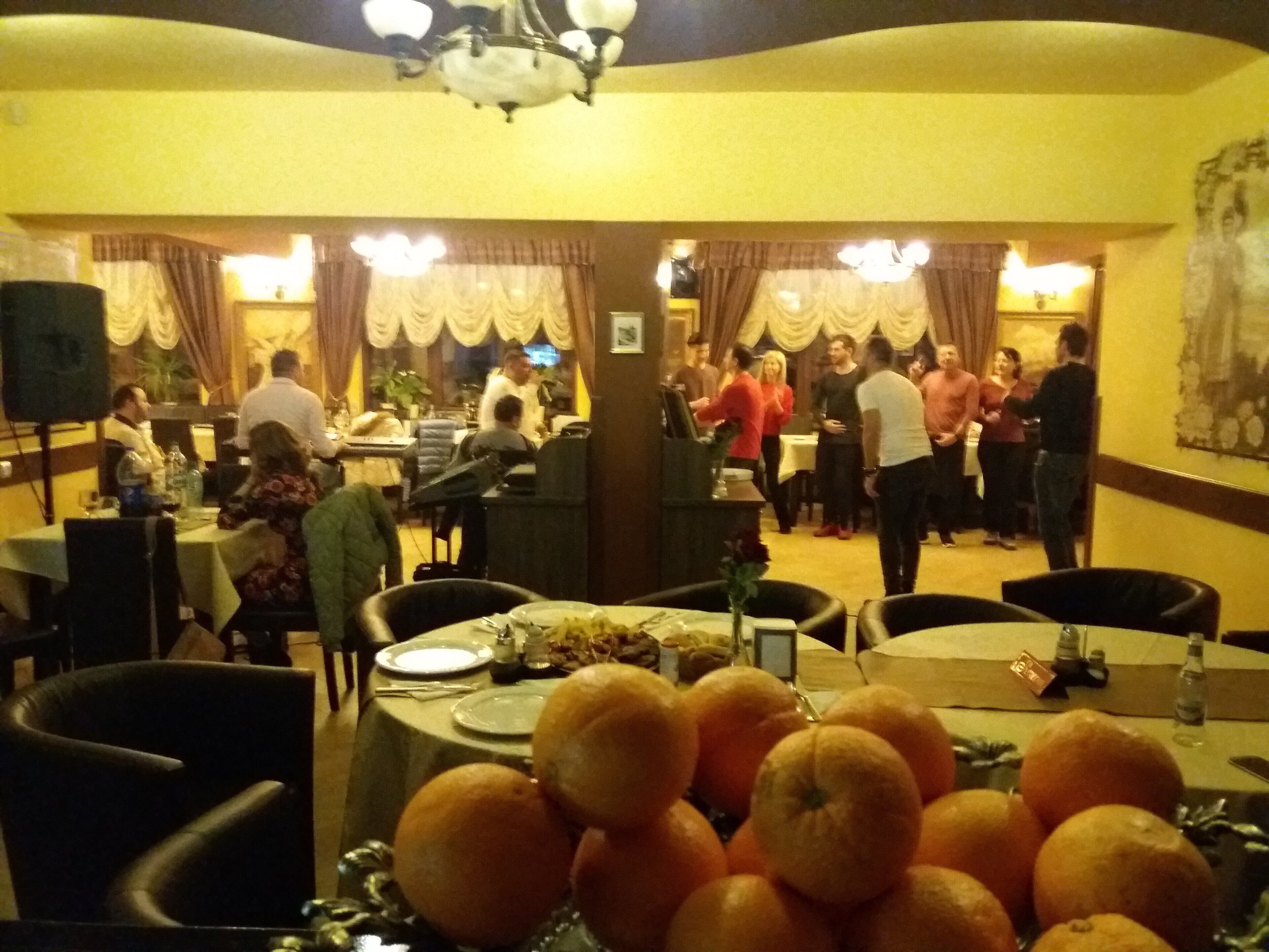 A restaurant with multiple tables, chairs, and a variety of dishes on the tables.
