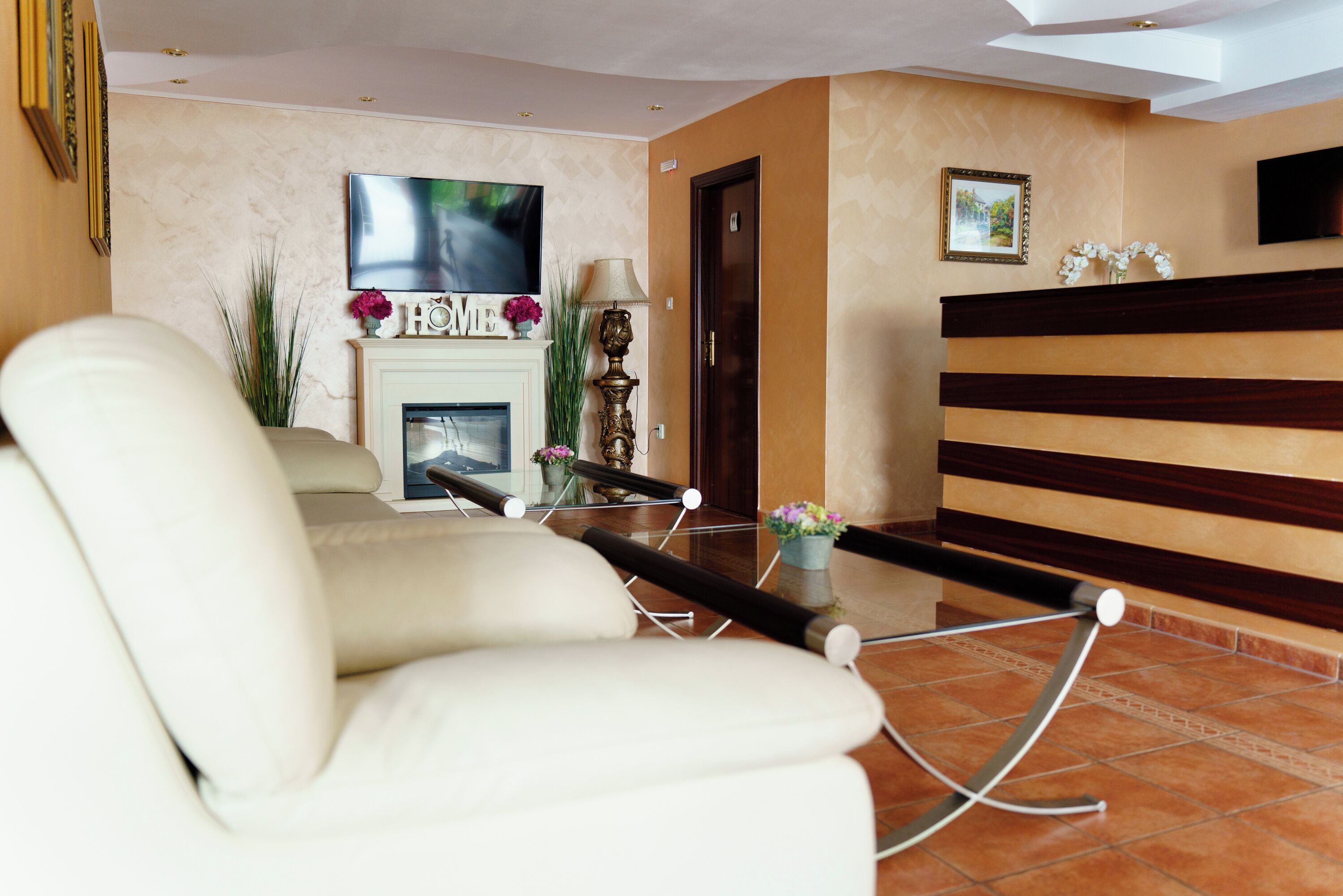 Una sala de estar moderna con un sofá, una chimenea, un televisor y un mostrador de recepción.
