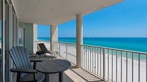 Un balcon avec vue sur la plage et l’océan.