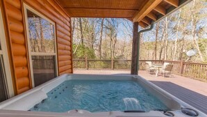 Ein Whirlpool auf einer Holterrasse mit Blick auf Bäume.
