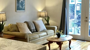 A living room with a sofa, two lamps, a coffee table, and a door leading outside. - Quiet, comfortable home. Near Intel and Nike campuses. (Hillsboro)