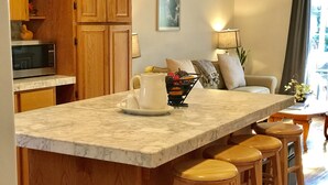 A kitchen with wooden cabinets, a marble countertop, a microwave, and a coffee maker. - Quiet, comfortable home. Near Intel and Nike campuses. (Hillsboro)