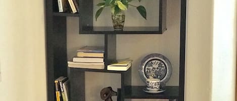 Une bibliothèque contenant divers objets, notamment des livres, un vase et des objets décoratifs.