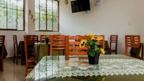 Een eethoek met een tafel voor vier personen, omringd door houten stoelen.