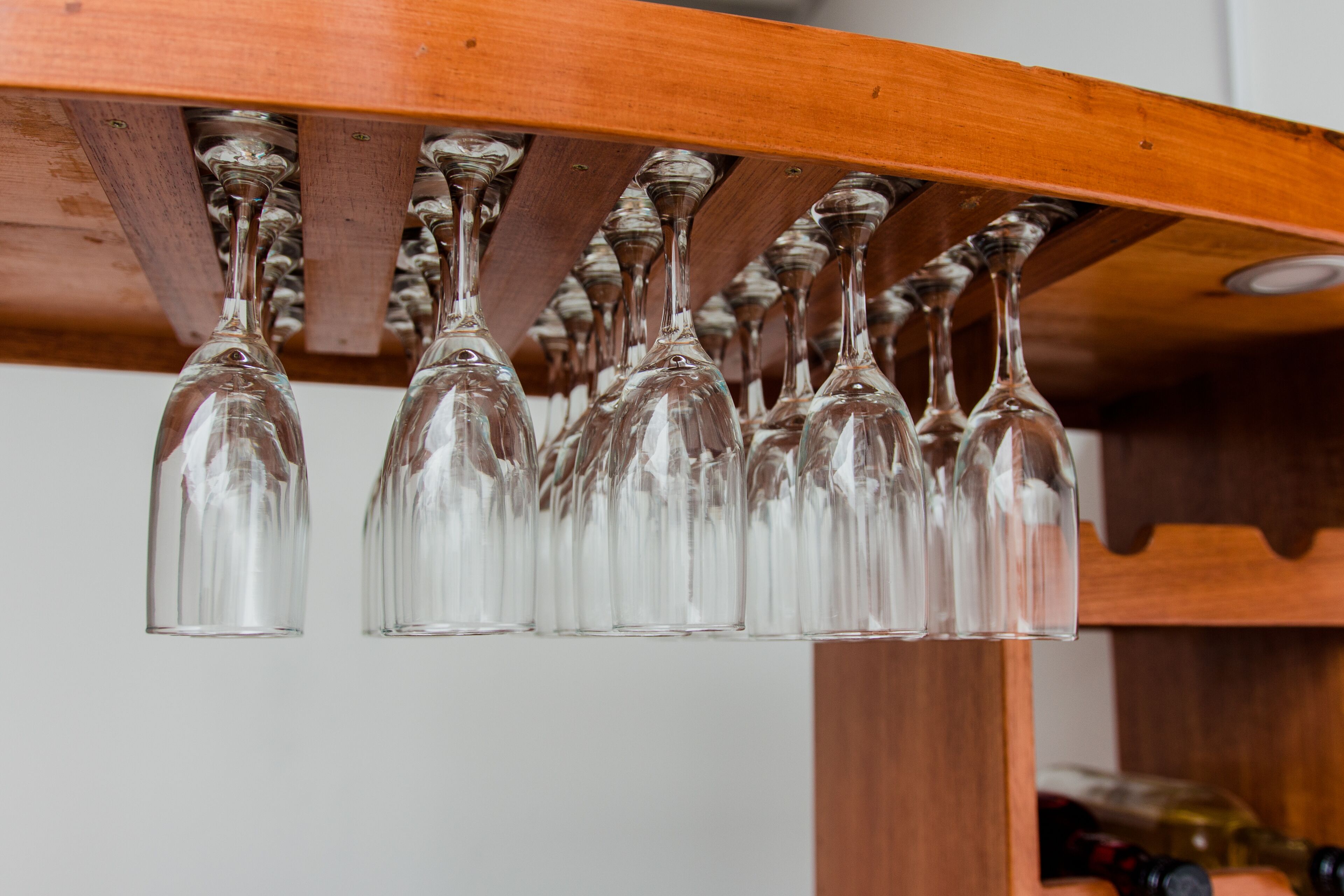 Un porte-bouteilles en bois contenant plusieurs verres à vin.