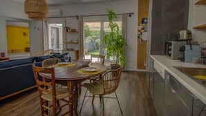 A compact living space with a dining area, kitchen, and a large sliding glass door leading to an outdoor area.