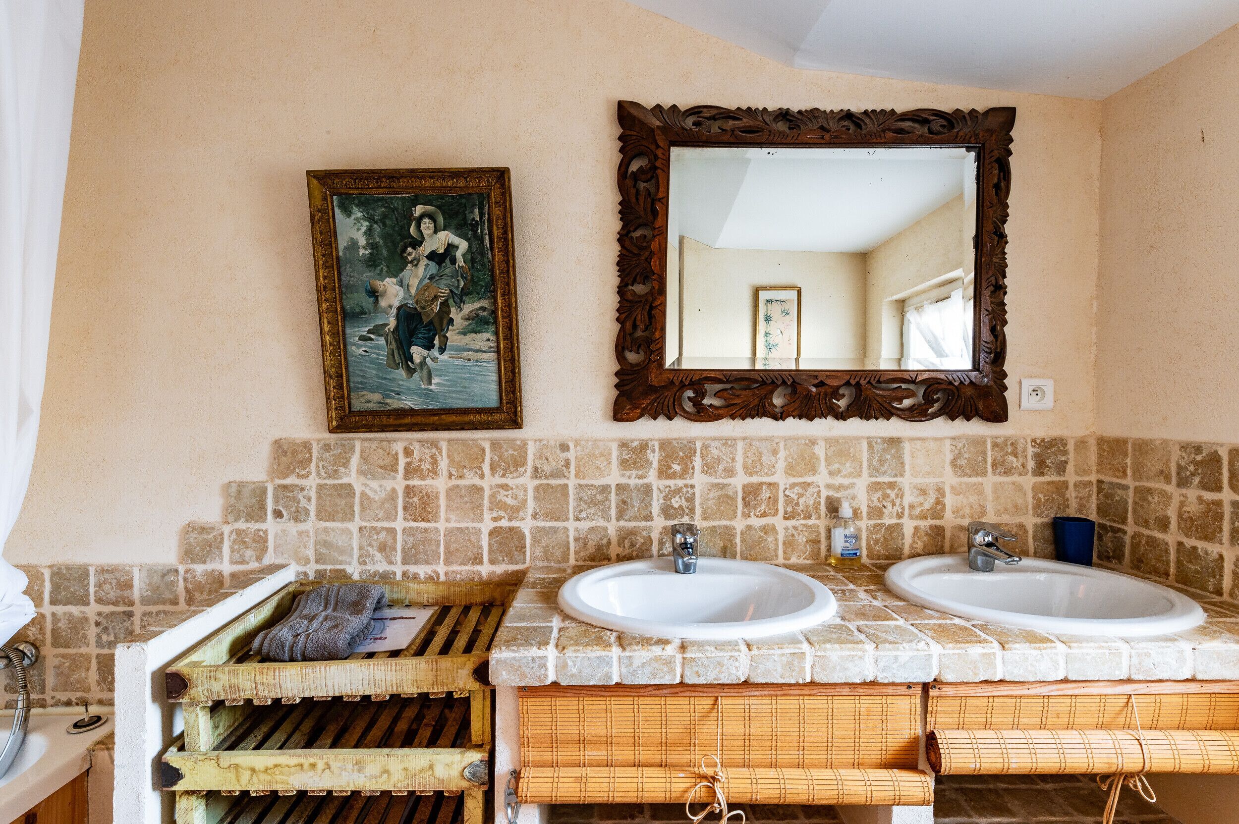 Un baño con dos lavamanos, un espejo y un cuadro en la pared.