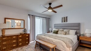 A bedroom with a bed, a wooden dresser, a bench, a ceiling fan, and a large mirror. - Scottsdale Chic Condo w/ Heated Pool, Walk Everywhere! A+ LUXURY in Old Town (Scottsdale)