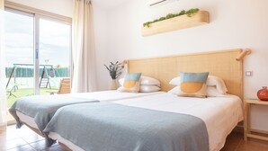 A hotel room with two beds, a large window, a view of a playground, and a mounted air conditioner. - Unique Family Villa! Spa, Ocean view, Heated Pool, Rooftop (Antigua)