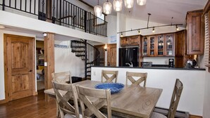 Une cuisine spacieuse dotée de meubles en bois, d’un îlot central et d’un coin repas avec des chaises.