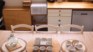 A kitchen with a view of trees, a microwave, a coffee maker, and a dishwasher.
