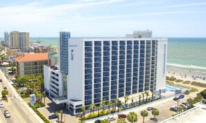 A hotel with a large number of balconies, a pool area, and a view of the beach. - Oceanfront Efficiency w/ Great View + Official On-Site Rental Privileges (Myrtle Beach)