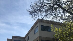 Un edificio de varios pisos con un estilo arquitectónico moderno, que cuenta con grandes ventanales y un techo plano.