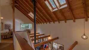 Een houten interieur met een trap die leidt naar een vide.