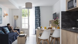 Ein modernes Wohnzimmer mit Sofa, Couchtisch und einem Essbereich mit Stühlen und Tisch.